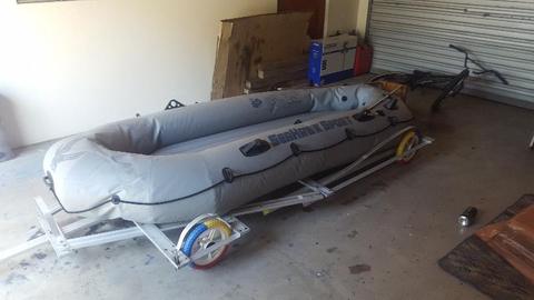 INFLATABLE RUBBER BOAT WITH ORS ON A SMALL MOBILE TRAILER - IN GOOD CONDITION
